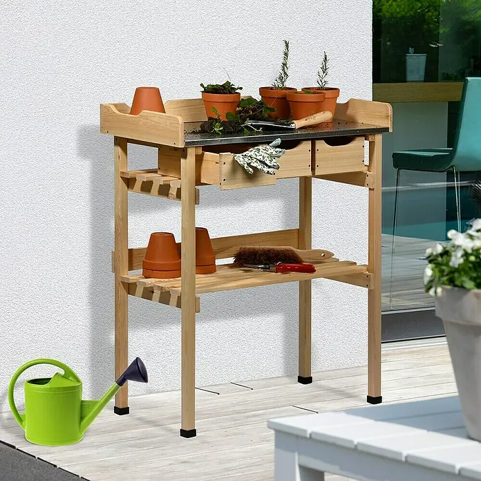 Dobar Pflanztisch - 78 x 38 x 88 cm, Holz, Natur - Ein Gartentisch aus Holz mit Pflanzgefäßen, Schubladen und einer grünen Gießkanne daneben. Praktisch für Gartenarbeiten im Freien.