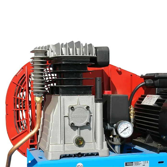 Güde Kompressor 635/10/90 Pro - 3.000 W, Max. Druck: 10 bar, 100 l, Schmierung: Ölgeschmiert - Nahaufnahme eines Kompressors mit rotem und blauem Gehäuse, silbernem Kompressorkopf mit Kühlrippen, sichtbarem Manometer und Kupferrohr.