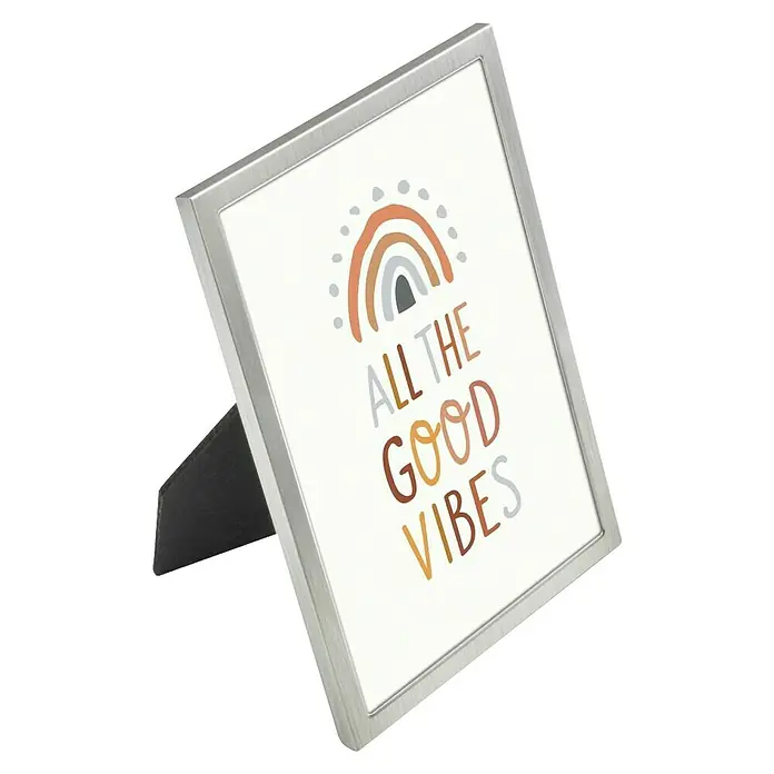 Hama Alurahmen Lia - 13 x 18 cm, Silber - Silberner Bilderrahmen aus gebürstetem Metall mit schwarzem Ständer, zeigt einen weißen Druck mit Regenbogen und „ALL THE GOOD VIBES“.