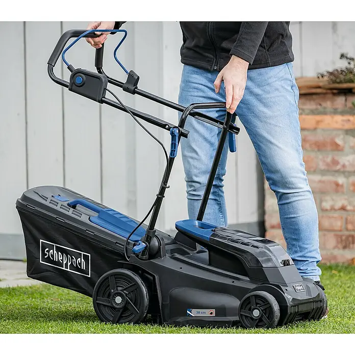 Scheppach IXES 20V Cortacésped de batería BC-MP380-X - 40 V, 2 baterías, 4 Ah, Ancho de corte: 38 cm - Un cortacésped Scheppach sobre una zona verde, sujetado por una persona que utiliza sus controles azules.