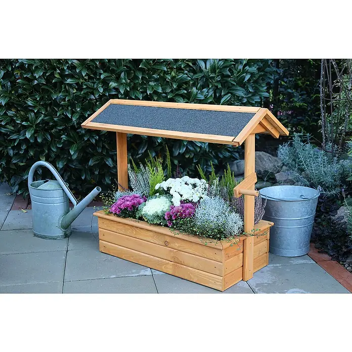Promadino Pflanzkasten Zierbrunnen Chiemsee - Außenmaß (L x B x H): 94,5 x 49 x 77 cm, Holz, Braun - Die rustikale Holzbrunnen-Pflanzkiste mit bunten Blumen und einem Zinkeimer neben einer Gießkanne ist ein Blickfang im Garten.