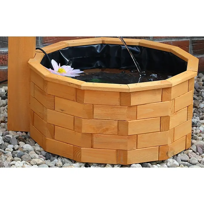 Promadino Standbrunnen - Ø x H: 64 x 101 cm, Solarpumpe - Nahaufnahme eines dekorativen Holzbrunnens im Freien, gefüllt mit Wasser und einer Seerose, der eine friedliche Gartenecke verschönert.