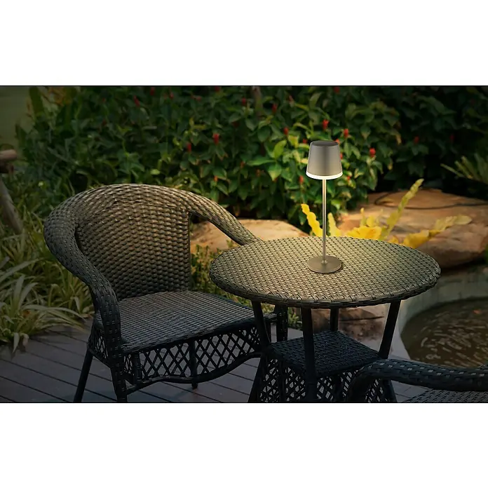 Globo Solar-Tischleuchte - Schwarz, Warmweiß, IP44, Ø x H: 11 x 41 cm - Eine stilvolle Tischlampe beleuchtet eine Gartengarnitur aus Rattan. Die Lampe spendet warmes Licht und sorgt für eine gemütliche Atmosphäre im Freien.
