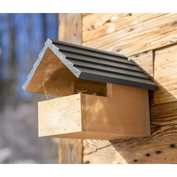 Windhager Nistkasten Loggia - Natur/Grau, Kiefer - Nahaufnahme eines hölzernen Vogelhauses mit dunklem Dach, befestigt an einer Holzwand, ideal für Vogelliebhaber.