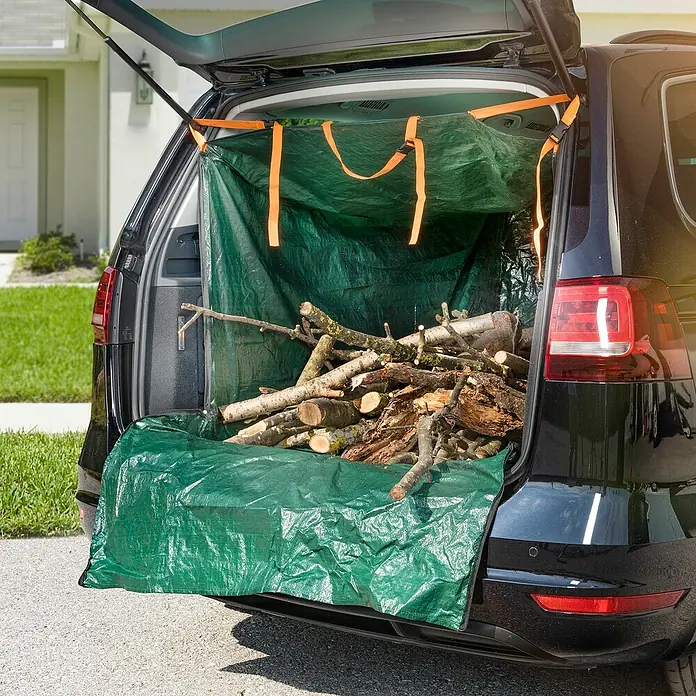 Windhager Gartenabfallsack Laderaumschutz - 170 x 120 cm, HDPE-Kunststoff - Ein grüner Kofferraumschutz mit Holzladung in einem schwarzen Auto, ideal für den Transport von Gartenabfällen oder Brennholz.