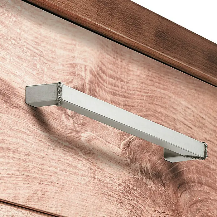 Häfele Tirador para muebles 100.45.027 - L x An x Al: 20,7 x 3,9 x 1,5 cm - Primer plano de un tirador de mueble plateado y rectangular con detalles decorativos sobre un mueble de madera.