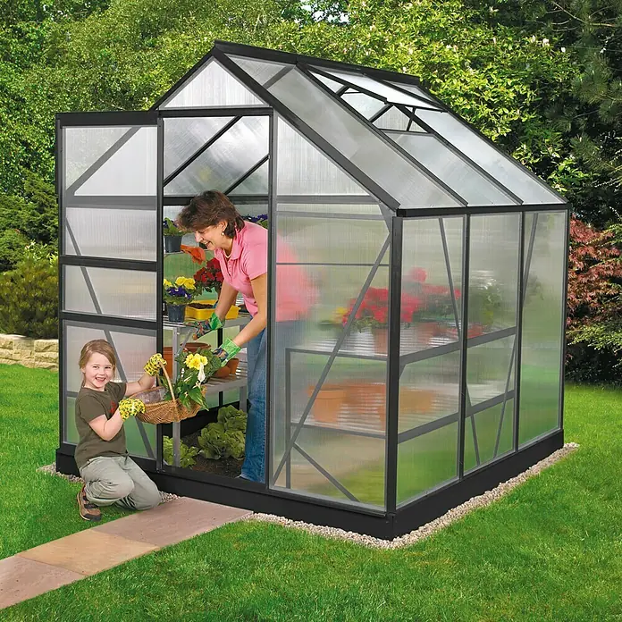 Vitavia Gewächshaus Venus 2500 - Außenmaß inkl. Dachüberstand (B x T): 195 x 131 cm, 4 mm, Schwarz - Ein geräumiges Gewächshaus aus schwarzem Metall mit transluzenten Wänden, in dem eine Frau mit einem Kind arbeitet.