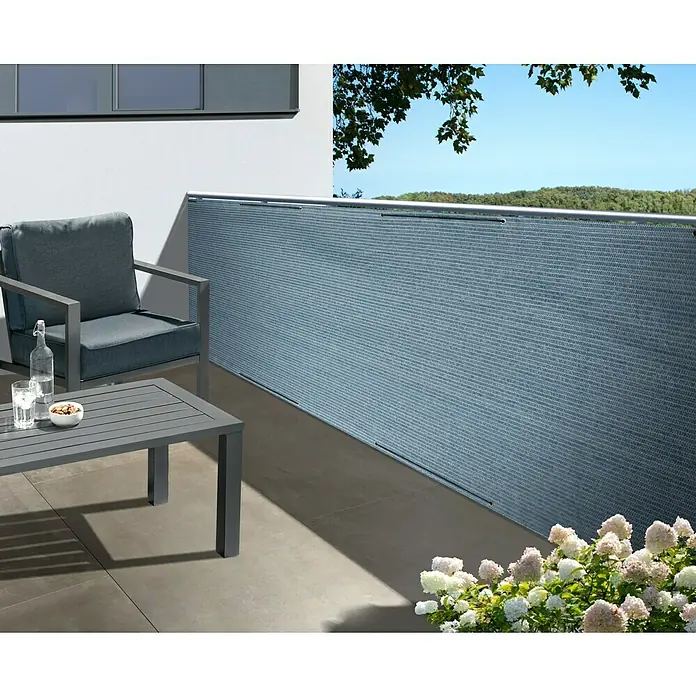 Gardol Sichtschutz - 5 x 0,9 m, Hellblau - Ein stilvoller Balkon mit einem Sichtschutz in Grau, einem passenden Sessel und Tisch, der Privatsphäre und Komfort vereint.