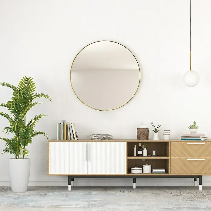 Rahmenspiegel Lara - Durchmesser: 70 cm, Gold/Schwarz, Metall - Wohnzimmer-Interieur mit einem modernen Sideboard aus Holz, einem runden Spiegel und einer Zimmerpflanze in einem hellen, minimalistischen Raum.