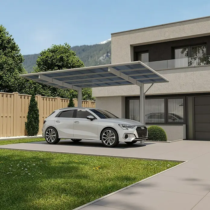 Ximax Carport Wing Typ 80 - Außenmaß inkl. Dachüberstand (B x T): 2,76 x 5,31 m, Einzelcarport, Silber - Ein hellgraues Carport mit lichtdurchlässigen Dachpaneelen schützt ein weißes Auto neben einem modernen Haus.