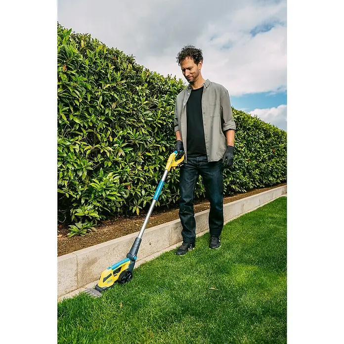 Gloria Griffverlängerung FineCut 18V compact Drive&Cut - Passend für: Gloria Power for All 18V Akku-Gras- & Strauchschere FineCut 18V compact - Ein Mann benutzt einen Akku-Rasenkantenschneider von Gardena, um die Rasenkanten zu bearbeiten. Das Gerät ist gelb und blau.