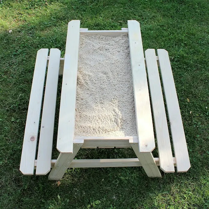 Soulet Kinder-Picknicktisch - L x B x H: 915 x 900 x 500 mm, Holz - Ein hölzerner Sandkasten mit Sitzbänken an den Seiten, gefüllt mit hellem Sand, steht auf einer grünen Rasenfläche. Ideal für Kinder zum Spielen.