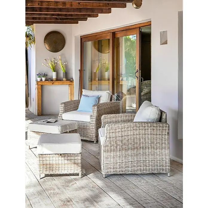 Sillón de exterior Gotland - An x Pr x Al: 80 x 81 x 77 cm, Aluminio/Ratán sintético, Beige - Acogedor patio con dos sillones de mimbre y reposapiés con cojines claros, perfecto para relajarse al aire libre.