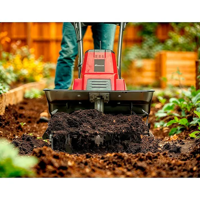 Hurricane Elektro-Bodenhacke HEB-I-1500 - Leistung: 1.500 W, Arbeitsbreite: 45 cm, Arbeitstiefe: 20 cm - Nahaufnahme eines roten Hurricane-Motorhackers, der Erde in einem Gartenbeet aufwirbelt, was seine Leistung und Vielseitigkeit hervorhebt.