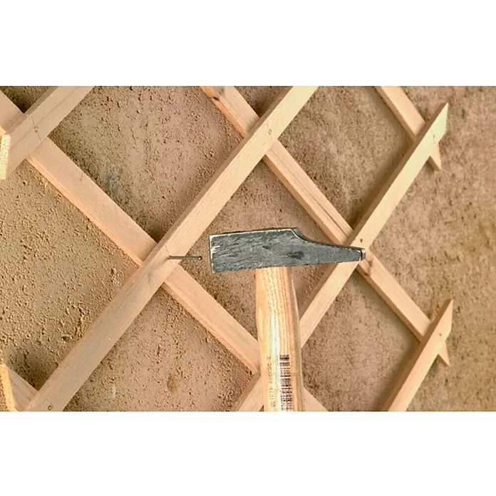 Nortene Celosía Trelliwood - An x Al: 0,5 x 1,5 m, Extensible, Natural - Un martillo clava un clavo en un enrejado de madera. La herramienta es robusta y está diseñada para trabajos manuales.