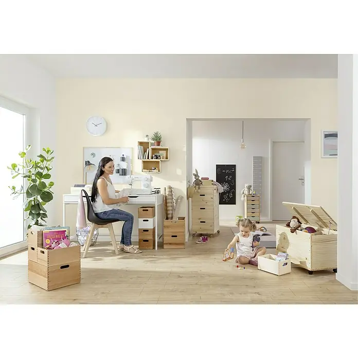 Zeller Present Tabletteinsatz S - L x B x H: 17 x 26,5 x 5 cm, Passend für: Stapelbox S - Kinderspielzimmer mit Holzkisten: Eine Frau näht, während ein Kind spielt, alles in einer gemütlichen, hellen Umgebung.
