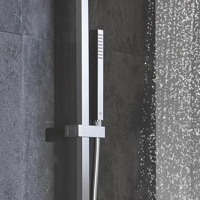 Grohe Euphoria Cube Handbrause Stick - Anzahl Funktionen: 1 Stk., 14 l/min, Chrom - Modernes Duschsystem aus Chrom mit rechteckiger Handbrause an dunkler Fliesenwand, Wassertropfen sichtbar.