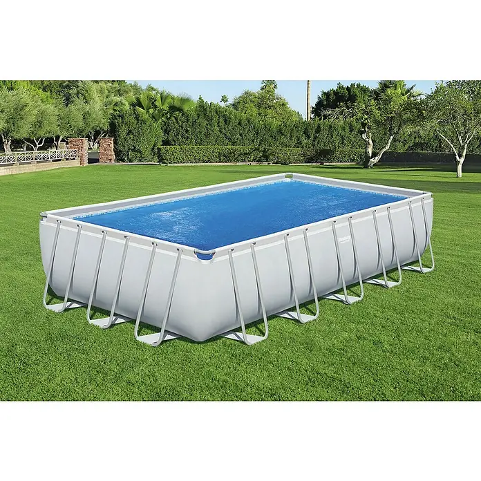 Bestway Solarabdeckplane - L x B: 336 x 703 cm, Material: Kunststoff - Rechteckiger grauer und weißer Aufstellpool mit blauer Wasserabdeckung, im Garten aufgestellt.