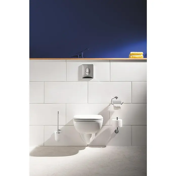 Grohe QuickFix Start WC-Bürstengarnitur - Metall - Ein modernes Badezimmer mit einer wandmontierten Toilette, weißen Fliesen und einem Holzbord mit dekorativen Elementen.