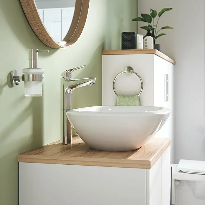 Grohe Grifo Swift XL - Brillante, Cromo - Un elegante lavabo de baño con grifo, dispensador de jabón y espejo, combinado con un mueble de baño en blanco y efecto madera.