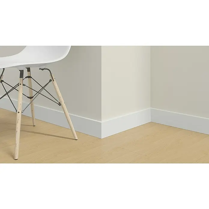 Profiles and more Sockelleiste FU123C - 2.400 x 24 x 92 mm - Detailansicht eines modernen weißen Stuhls mit Holzbeinen vor einer hellen Wand und Fußleisten. Die klaren Linien betonen das schlichte Design.