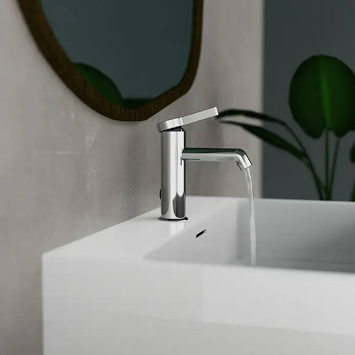 Camargue Waschtischarmatur Signo - Chrom, Glänzend - Nahaufnahme eines modernen Chrom-Wasserhahns auf einem weißen Waschbecken mit fließendem Wasser, hervorgehoben durch ein ovales Spiegelbild.