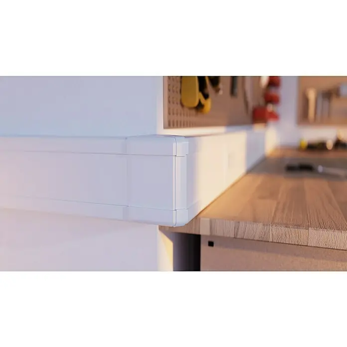 Außeneck BR 70 - Passend für: Brüstungskanal BR 70 x 130 mm, Reinweiß - Nahaufnahme einer Werkbank mit weißem Aufbewahrungsschrank zur Wandmontage, der zusätzlichen Stauraum bietet.