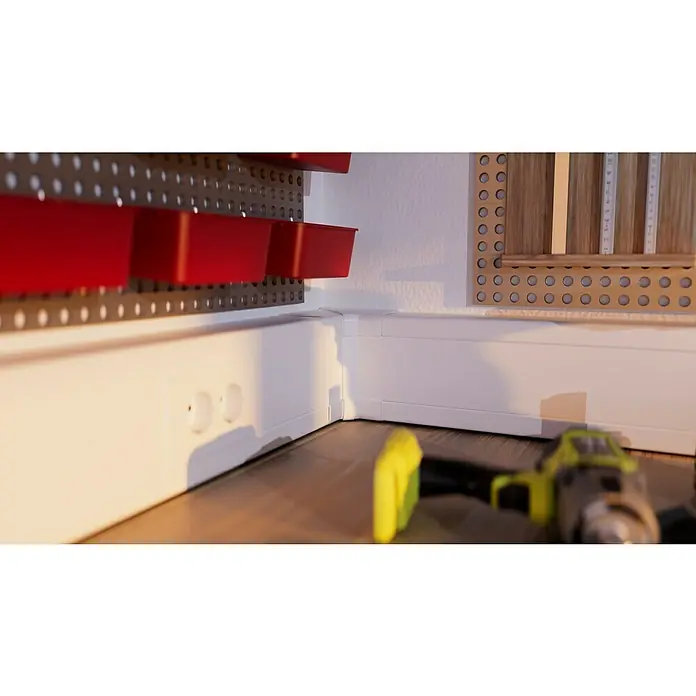 Inneneck-Profil - Passend für: Brüstungskanal BR 70 x 130 mm, Reinweiß - Eine Nahaufnahme eines Akku-Bohrschraubers vor einer Werkbank mit Lochplattenwand und roten Behältern.