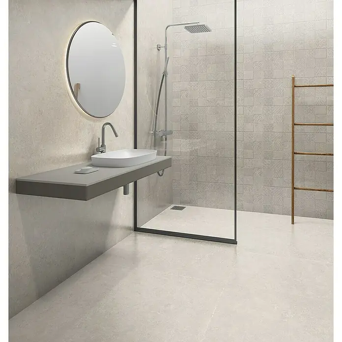 Revestimiento de pared Geo - 30 x 90 cm, Greige, Mate, Rectificado - Baño luminoso con un lavabo elegante, espejo y ducha. El diseño moderno crea un ambiente relajante.