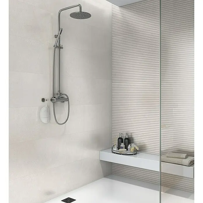 Revestimiento de pared Mood - 30 x 90 cm, Pearl, Mate, Rectificado - Una moderna cabina de ducha con un elegante sistema de ducha y espacio para artículos de tocador para mejorar la experiencia.