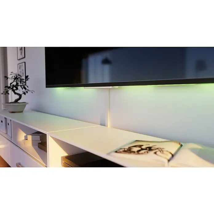 Kabelkanal - L x B x H: 2 m x 30 mm x 15 mm, Weiß - Ein moderner Fernseher mit stimmungsvoller Hintergrundbeleuchtung, montiert über einem weißen Lowboard. Ein Bonsai-Baum sorgt für einen natürlichen Akzent im Raum.