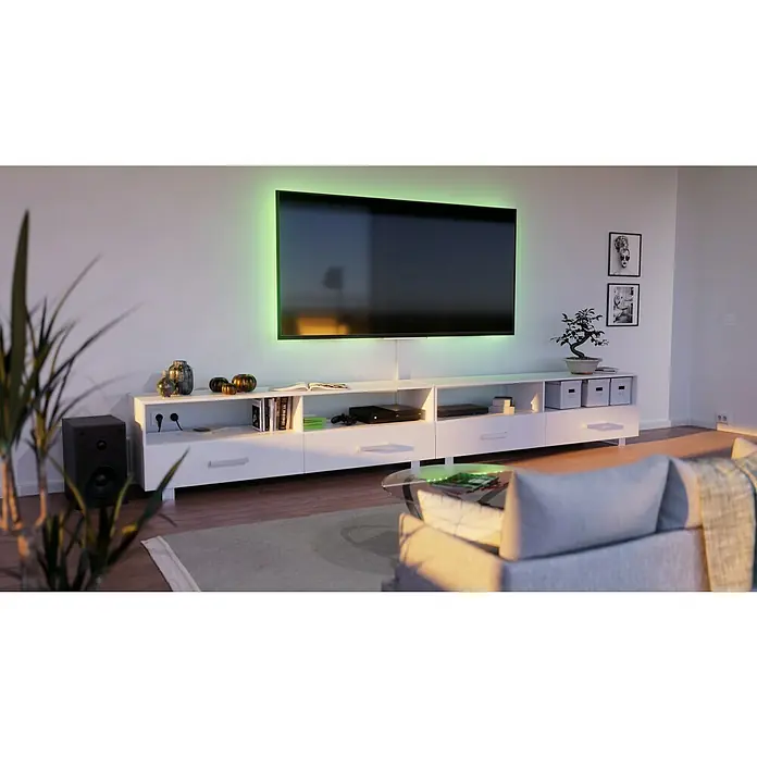 GGK Endstück - Rechts, Alpinweiß, Passend für: Sockelleistenkanal SL 20x50 - Modernes Wohnzimmer mit großem Fernseher, der von grünen LED-Streifen beleuchtet wird, und weißen Möbeln.