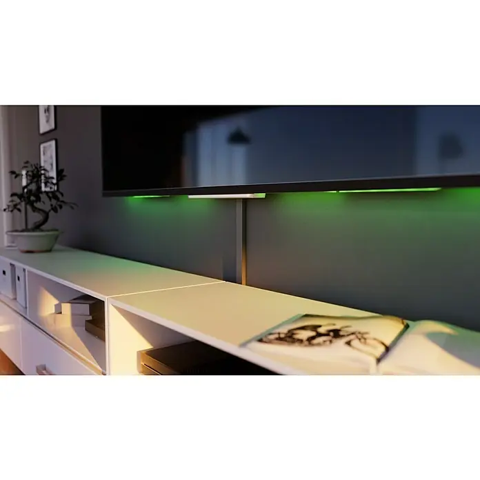 Kabelkanal - L x B x H: 2 m x 30 mm x 15 mm, Silber - Ein modernes Wohnzimmer mit einem eleganten TV und einer stilvollen TV-Bank, die mit grünen LED-Leuchten akzentuiert ist und eine entspannende Atmosphäre schafft.
