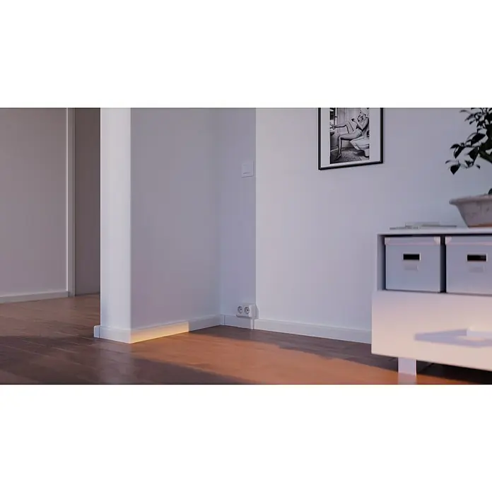 GGK Außeneck - Alpinweiß, Passend für: Sockelleistenkanal SL 20x50 - Innenaufnahme eines Zimmers mit einem hölzernen Boden, weißen Wänden, einem Schrank und einem Bild an der Wand.