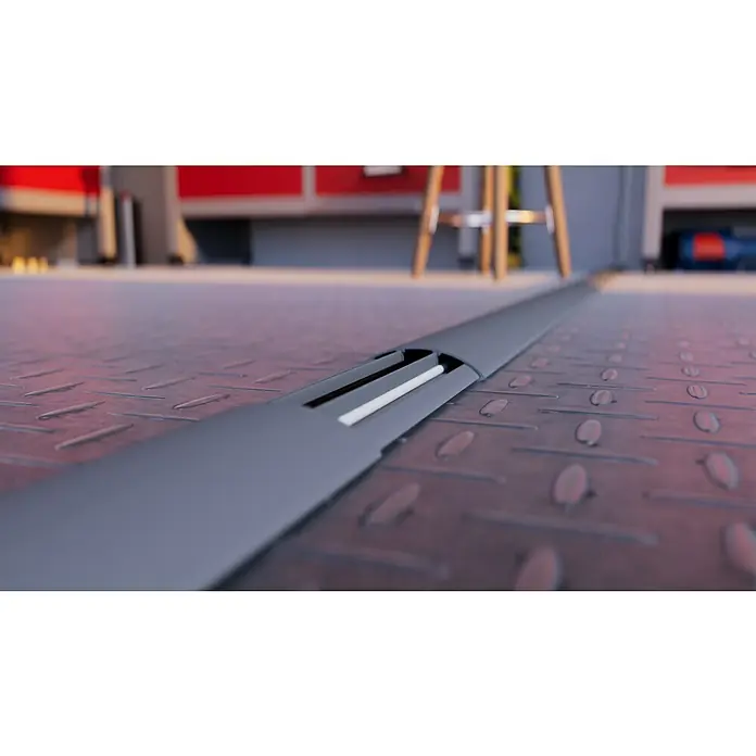 Aufbodenkanal - Länge: 2 m, PVC - Detailaufnahme einer grauen Kabelbrücke mit Kabelkanal auf einem robusten Industrieboden, ideal für Werkstätten oder Produktionsstätten.