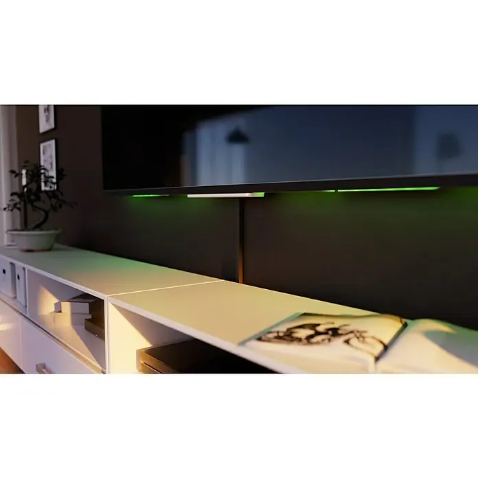 Kabelkanal - L x B x H: 2 m x 15 mm x 15 mm, Braun - Nahaufnahme eines modernen Wohnzimmers mit einem Fernseher, der über einem weißen Medienschrank montiert ist, und stimmungsvoller grüner Beleuchtung.