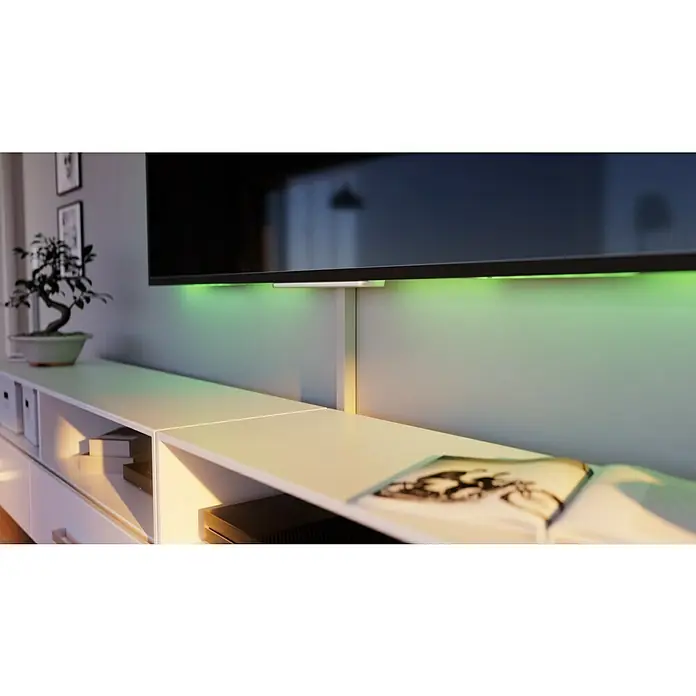 OBO Kabelkanal - 2 m x 30 mm x 30 mm, Lichtgrau - Ein moderner, weißer Entertainment-Center-Schrank mit Ambient-Beleuchtung unter dem Fernseher, ideal für ein stilvolles Wohnzimmer.