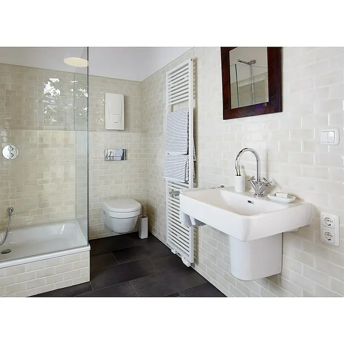 Clage Durchlauferhitzer DBX 21 Next - 21 kW, Elektronisch, Druckfest - Modernes Badezimmer mit hellen Wandfliesen, dunklem Boden, Dusche, Wand-WC und Waschbecken, ergänzt durch einen Handtuchwärmer.