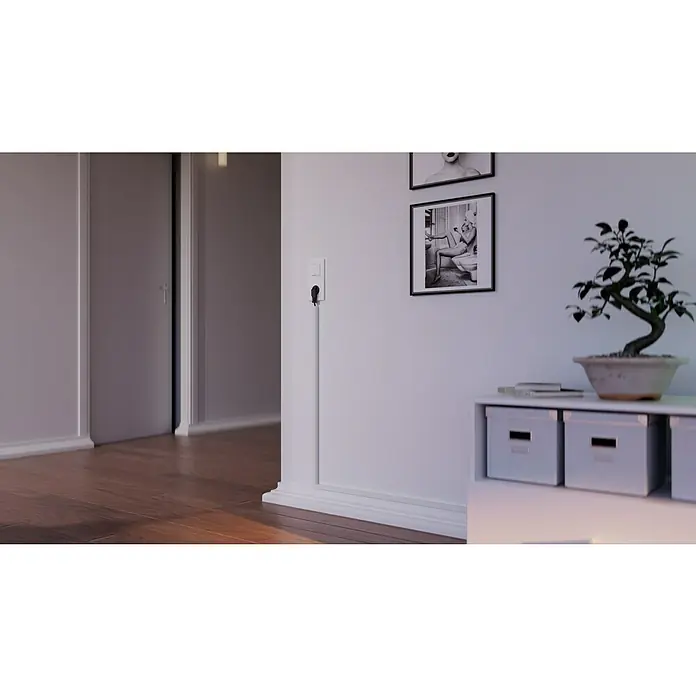 OBO Kabelkanal - 2 m x 15 mm x 15 mm, Reinweiß - Innenaufnahme mit einer Zimmerpflanze auf einem weißen Sideboard, Fotos an der Wand und einem Holzboden.