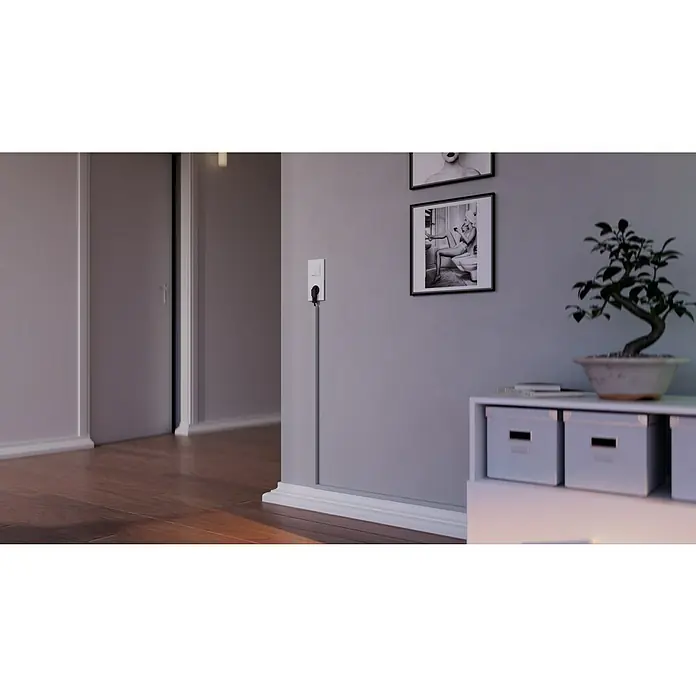 OBO Kabelkanal - 2 m x 15 mm x 15 mm, Lichtgrau - Ein modernes Interieur mit einem stilvollen Bonsai auf einem weißen Schrank, neben gerahmten Bildern und einem diskreten Stromkabel an der Wand.
