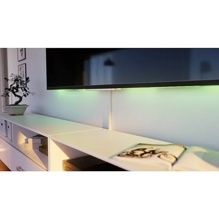 OBO Kabelkanal - 2 m x 15 mm x 15 mm, Reinweiß - Ein moderner Fernsehschrank mit integrierter LED-Beleuchtung unter dem Fernseher, der eine angenehme Atmosphäre im Raum schafft.