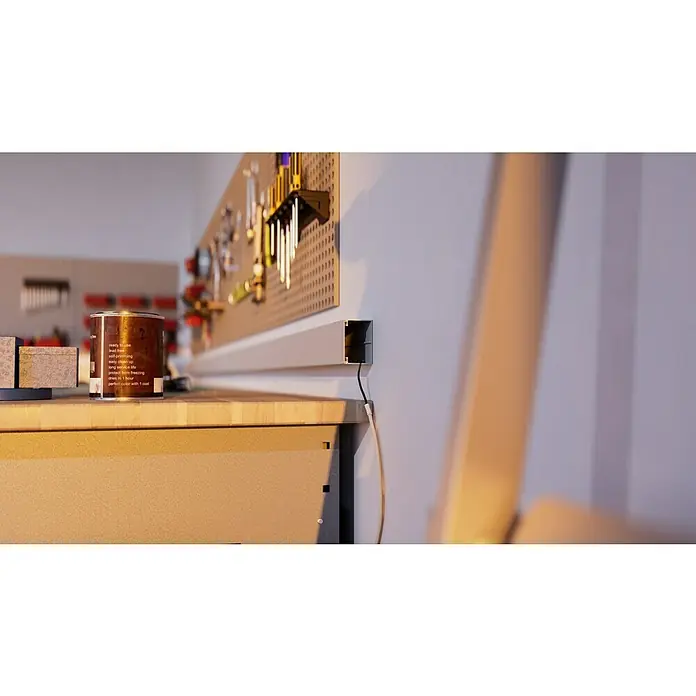 OBO Kabelkanal - 2 m x 60 mm x 40 mm, Lichtgrau - Nahaufnahme einer Farbdose auf einer Werkbank mit Werkzeugen an der Wand, die die Details und die Beschaffenheit der Farbe hervorhebt.