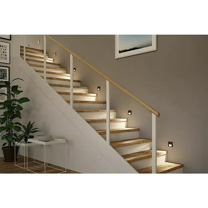 Paulmann LED-Wandleuchte Tsaro Leader - L x B x H: 3,6 x 8 x 8 cm, Warmweiß, Schwarz matt - Treppe mit Holzstufen und weißen Setzstufen, beleuchtet durch quadratische Wandleuchten, ergänzt durch ein Bild und Pflanzen.