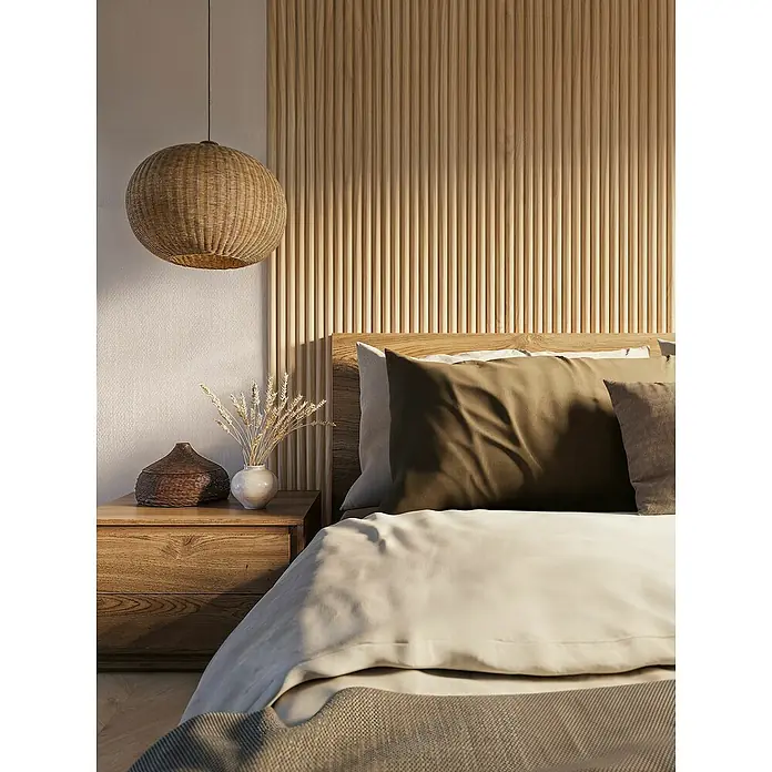 CanDo Akustikpaneel Curve - Eiche Natur Uni, 2.600 x 300 x 19 mm, 2 Stk. - Nahaufnahme eines Schlafzimmers mit einem geflochtenen Lampenschirm und einem Bett mit Kissen und Überwurf.