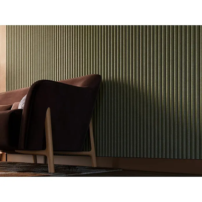 CanDo Akustikpaneel Curve - Sage, 2.600 x 300 x 19 mm, 2 Stk. - Elegantes braunes Sofa vor einer Wand mit vertikalen, olivgrünen Akustikpaneelen, die dem Raum Struktur und Wärme verleihen.