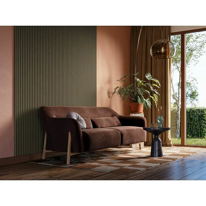 CanDo Akustikpaneel Curve - Sage, 2.600 x 300 x 19 mm, 2 Stk. - Dieses Bild zeigt ein stilvolles braunes Sofa mit Zierkissen in einem modernen Wohnzimmer. Die Szene wird durch warme Farben und Texturen ergänzt.
