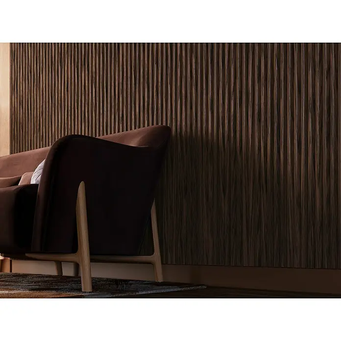 CanDo Akustikpaneel Curve - Walnuss Uni, 2.600 x 300 x 19 mm, 2 Stk. - Elegantes Interieur mit einem braunen Sofa vor einer Wand mit vertikalen Holzpaneelen, die eine warme und stilvolle Atmosphäre schaffen.