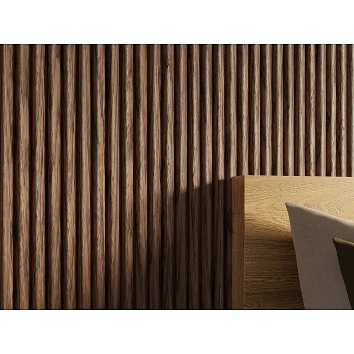 CanDo Akustikpaneel Curve - Walnuss Uni, 2.600 x 300 x 19 mm, 2 Stk. - Detailaufnahme einer Holzwand mit vertikalen Lamellen, teilweise im Schatten, daneben ein helles Holzbettgestell mit Kissen.