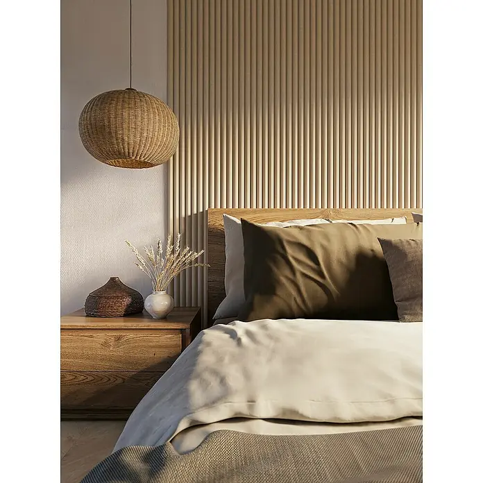 CanDo Akustikpaneel Curve - Sand, 2.600 x 300 x 19 mm, 2 Stk. - Nahaufnahme eines Schlafzimmers mit einem Nachttisch aus Holz, einer Rattanlampe und einem Bett mit Kissen und einer Decke.