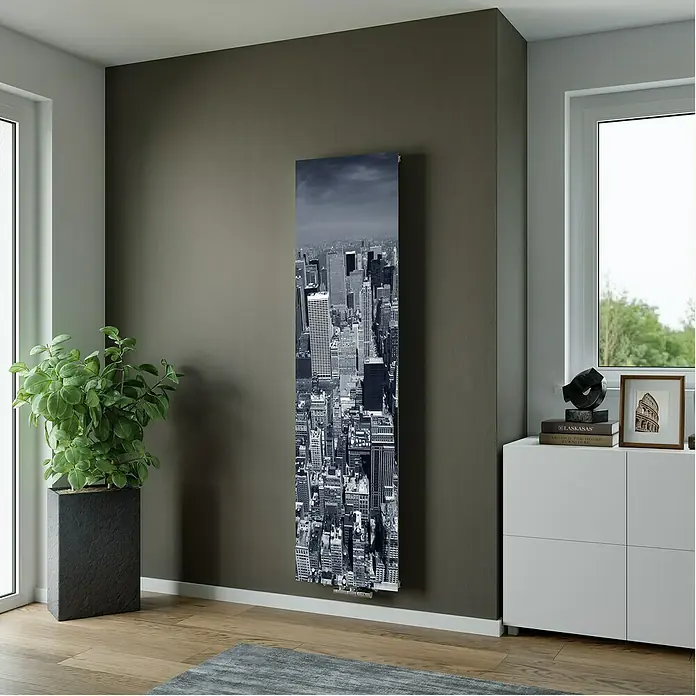 Ximax Designheizkörper - B x H: 599 x 1.800 mm, Wärmeleistung bei Vorlauftemperatur von 75 °C (D: 50): 893 W, New York - Langer, schlanker Designheizkörper mit Schwarz-Weiß-Stadtdruck, an dunkler Wand in einem Raum montiert.
